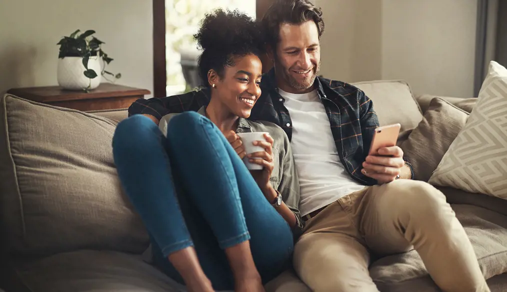 Couple on a sofa looking at a cell phone