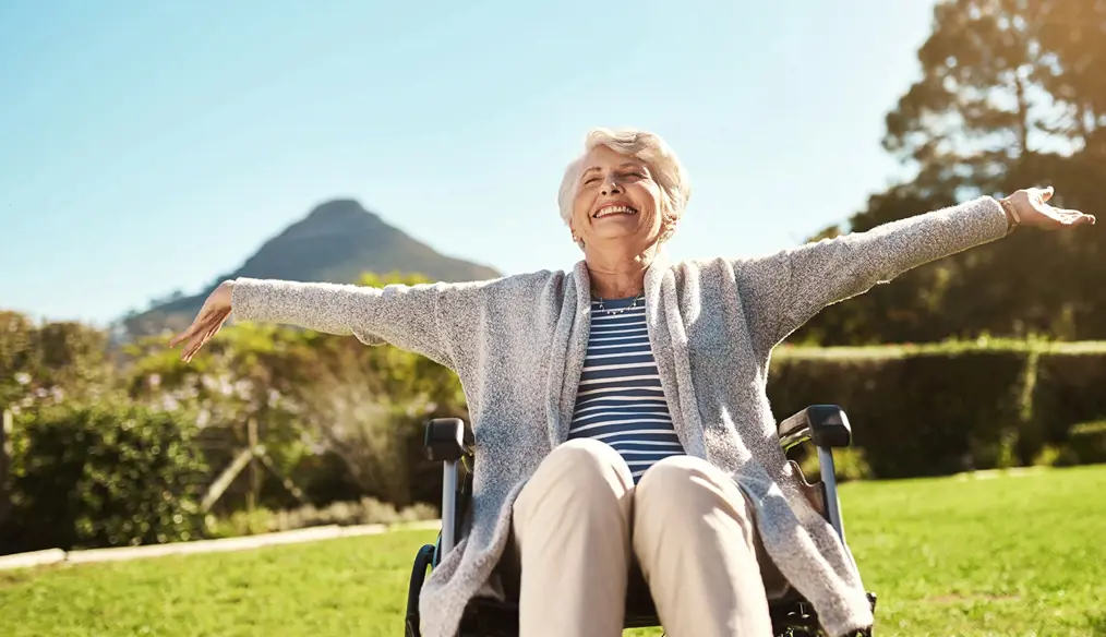 Woman in wheel chair, smiling with hands reached out