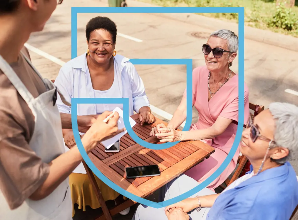 older women sitting together smiling outside