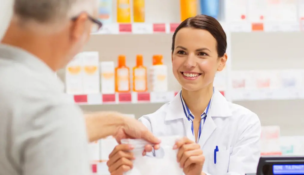 Man picking up prescription from pharmacist