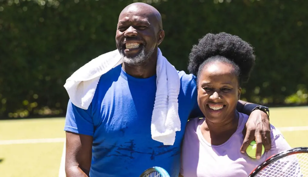 Couple on tennis court, smiling