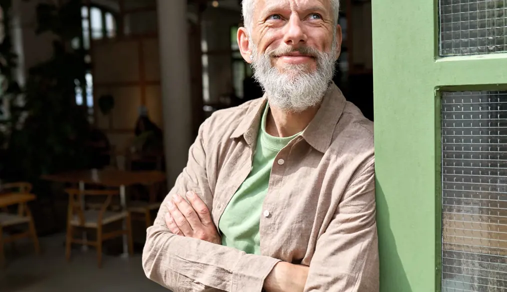 Man leaning against door, smiling