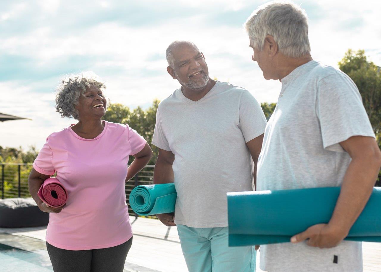 two men and a woman with yoga gear talking