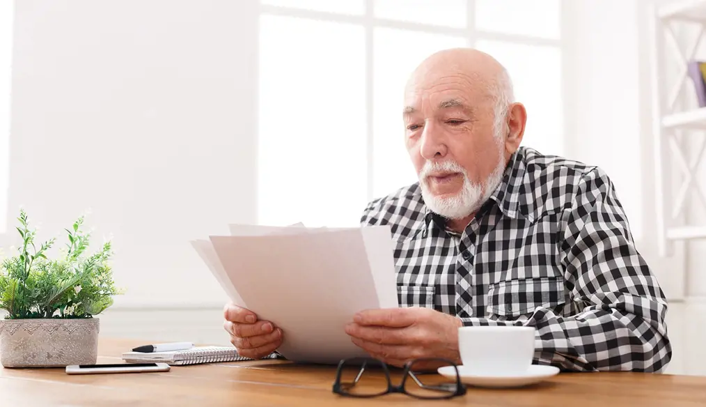 Man reviewing papers at home